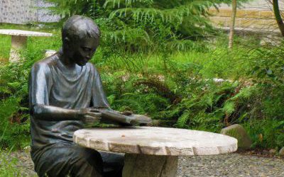 玻璃鋼仿銅公園里男孩坐著凳子上的讀書雕塑