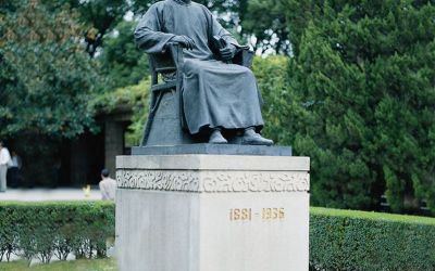 公園廣場(chǎng)大型景觀坐著石柱上面的玻璃鋼魯迅雕塑